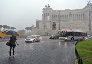 A woman crosses Piazza Venezia under pouring rain in downtown Rome, Tuesday, Aug. 27, 2013. (AP Photo/Gregorio Borgia)